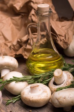 zeytin yağı, biberiye twigs ve taze mantar bitkisel bileşimi makro resmi. Yağ geçirmez kağıt arka plan üzerinde ham maddeler. Sebze yemek yemekler için kümesi. Pişirme kavramı.