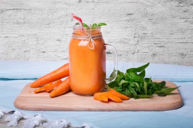 Havuç güler yüzlü bir mavi kumaş arka plan üzerinde kokteyl Close-Up.