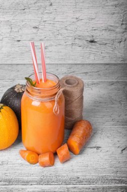 Bir kompozisyon rustik ahşap arka plan üzerinde doğal maddeler. Konuları Kangal, ince havuç kesim ve kabaklari parlak turuncu havuç suyu payet ile bir kavanoz yanında yuvarlak. Kopya alanı.