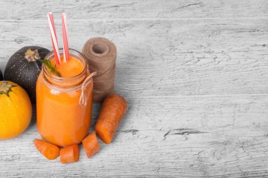 Bir kompozisyon rustik ahşap arka plan üzerinde doğal maddeler. Konuları Kangal, ince havuç kesim ve kabaklari parlak turuncu havuç suyu payet ile bir kavanoz yanında yuvarlak. Kopya alanı.