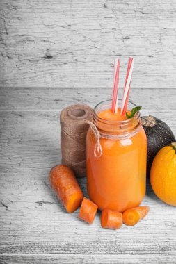 Bir kompozisyon rustik ahşap arka plan üzerinde doğal maddeler. Konuları Kangal, ince havuç kesim ve kabaklari parlak turuncu havuç suyu payet ile bir kavanoz yanında yuvarlak. Kopya alanı.