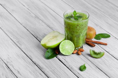 gri bir ahşap zemin üzerine cam yüzlü kivi, elma ve limon nane ile Üstten Görünüm.