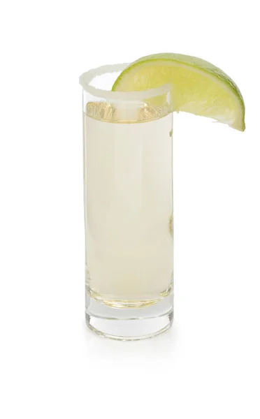 塩をショット グラスでメキシコのテキーラとライム グリーンのジューシーなスライス 白い背景で隔離のマルガリータ テキーラで作られていますカクテルのための飲料をホットします — ストック写真