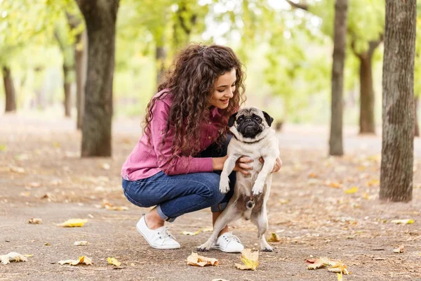 Linda chica morena paseando con el perro en el parque. Concepto animal . — Foto de Stock