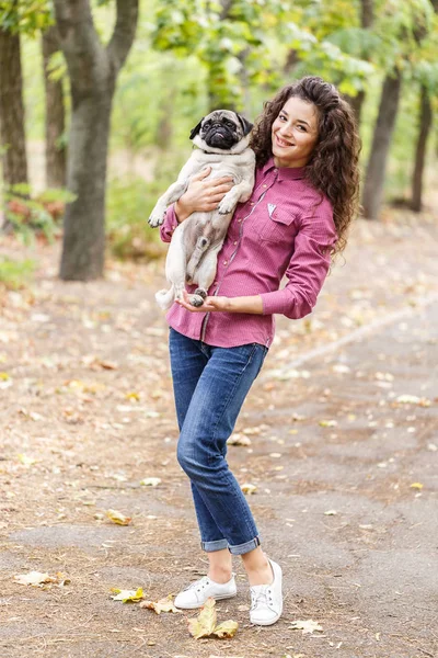 Linda chica morena paseando con el perro en el parque. Concepto animal . — Foto de Stock