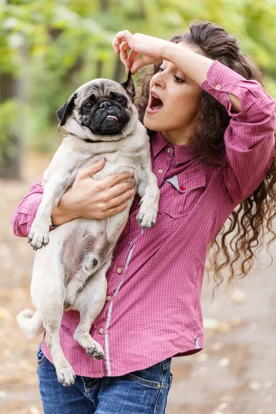 Linda chica morena paseando con el perro en el parque. Concepto animal . — Foto de Stock