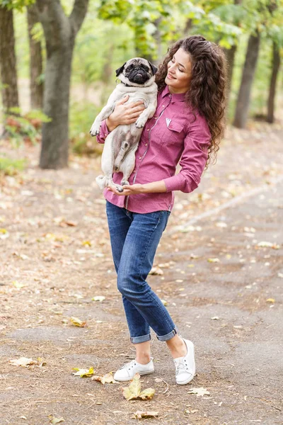 Linda chica morena paseando con el perro en el parque. Concepto animal . — Foto de Stock