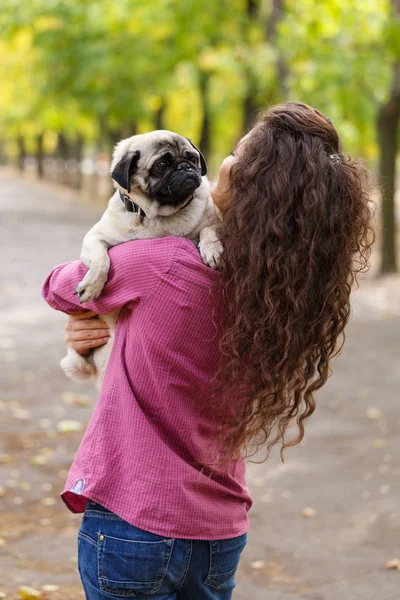 Linda chica morena paseando con el perro en el parque. Concepto animal . — Foto de Stock