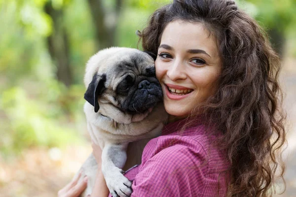 Linda chica morena paseando con el perro en el parque. Concepto animal . — Foto de Stock