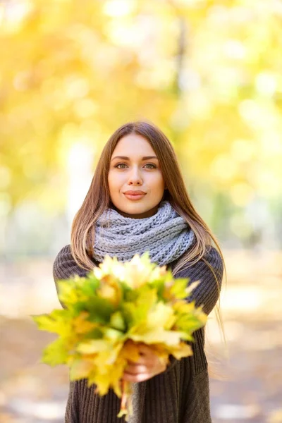 Kız ile sonbahar bir arka plan üzerinde siyah bir ceket yaprakları — Stok fotoğraf