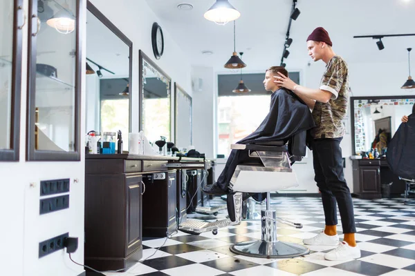 Fryzjera fryzjera parihopher strechot mały chłopiec siedzi na krześle — Zdjęcie stockowe
