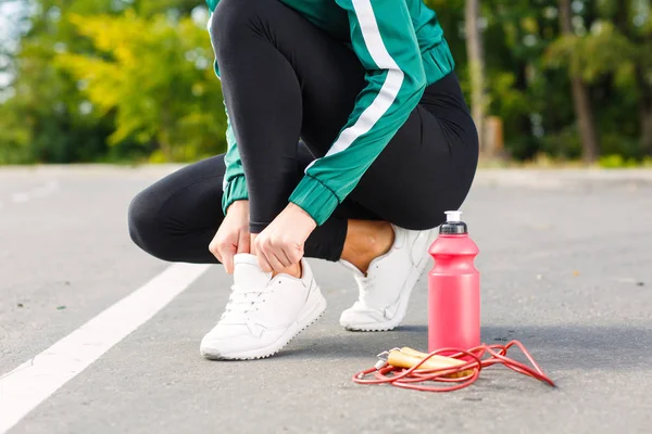 Genç bir sportif kadın spor ayakkabı bağcıkları bağları. Mükemmel vücut egzersizleri yapıyor bir kızla. — Stok fotoğraf