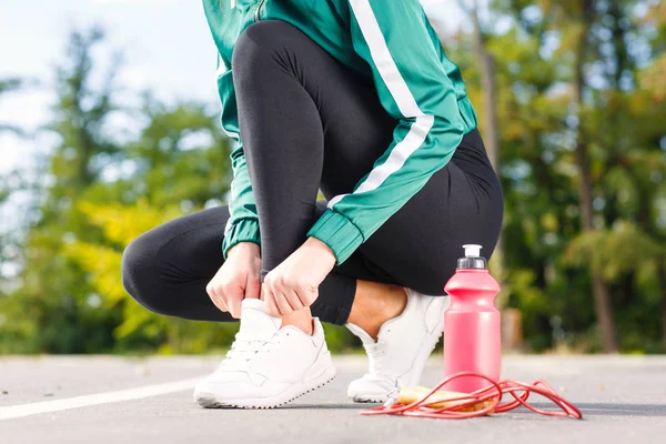 Genç bir sportif kadın spor ayakkabı bağcıkları bağları. Mükemmel vücut egzersizleri yapıyor bir kızla. — Stok fotoğraf