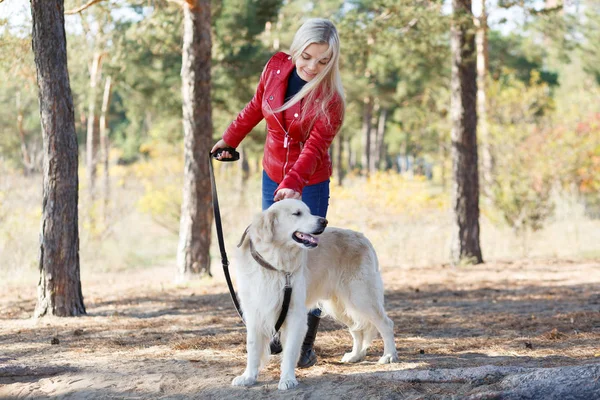 Linda chica rubia paseando con el perro en el bosque. Concepto animal . — Foto de Stock