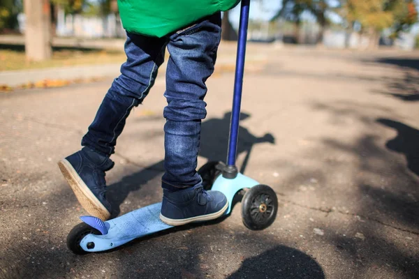 Un niño juega en otoño en la calle — Foto de Stock