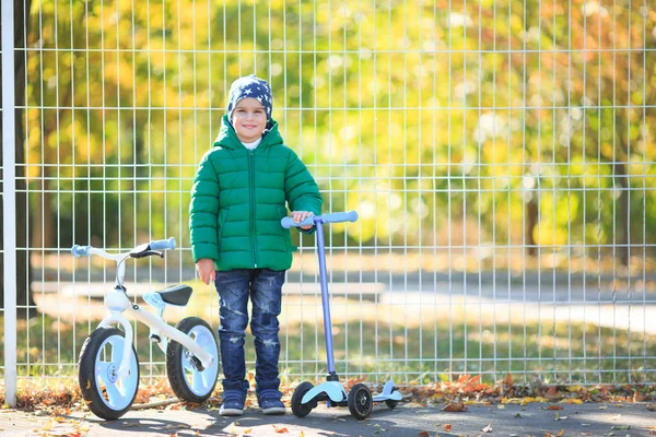 Un ragazzo gioca in autunno per strada — Foto Stock