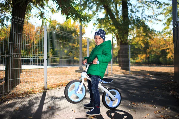 Ein Junge spielt im Herbst auf der Straße — Stockfoto