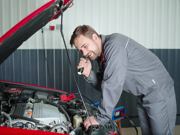 The mechanic under the hood is looking at the breakdown