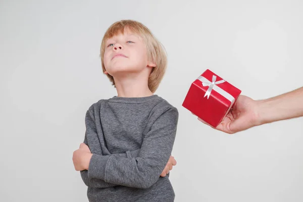 Kleine emotionele blonde jongen in een feestelijke rode hoed op een grijze achtergrond.. — Stockfoto