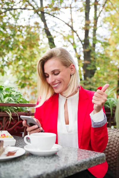 Бізнес-леді в кафе замовила десерт і п'є чай на відкритому повітрі — стокове фото