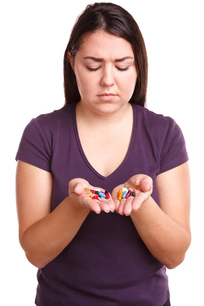 Девушка с таблетками хочет выпить все таблетки в ее руке — стоковое фото