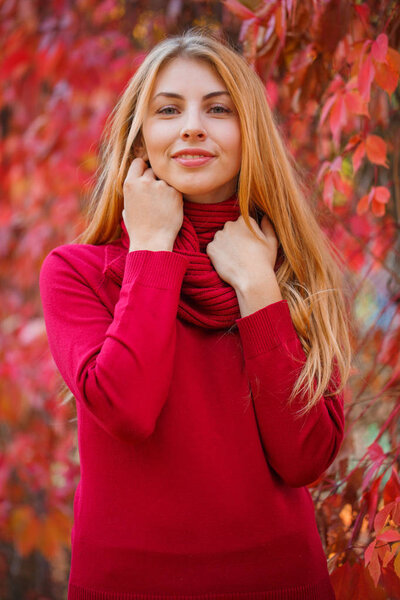 Young beautiful woman ith red hair in autumn park.