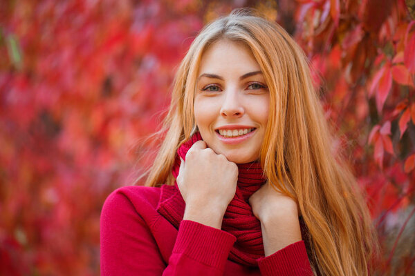 Young beautiful woman ith red hair in autumn park.