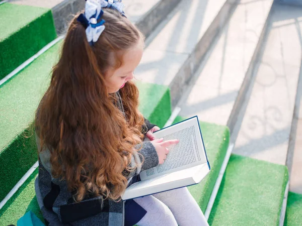 Девушка ходит в школу с портфелем и книгами — стоковое фото