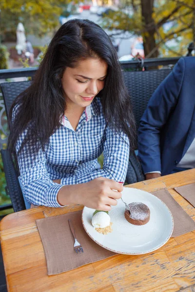 Щаслива молода жінка їсть торт у відкритому кафе . — стокове фото