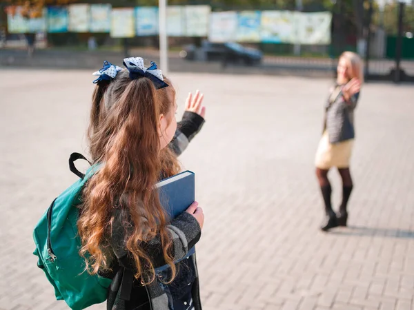 Het meisje gaat naar school met een werkmap en boeken — Stockfoto