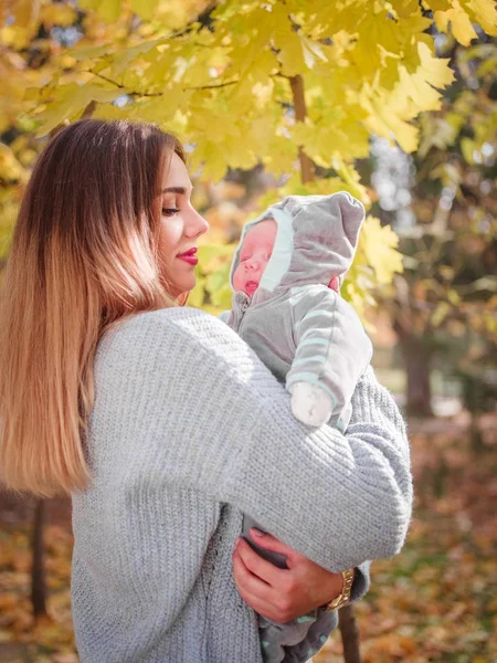 A menina está segurando seu filho no parque — Fotografia de Stock