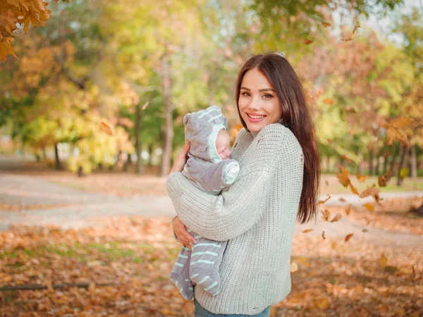 The girl is holding her son in the park — Stock Photo, Image