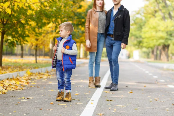 Famiglia, infanzia, concetto d'amore. Famiglia felice che gioca con foglie autunnali nel parco. Una famiglia olandese. Mamma e papà con figlio . — Foto Stock