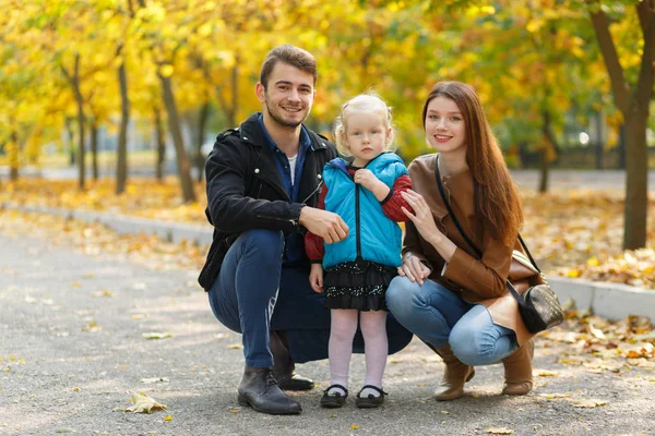 Famille, enfance, concept d'amour. Bonne famille jouant avec les feuilles d'automne dans le parc. Vacances en famille. Maman et papa avec fille . — Photo