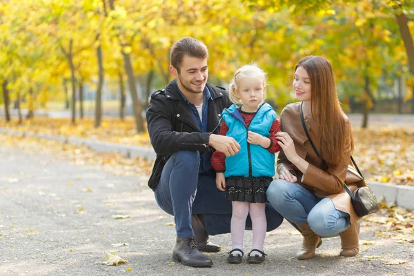 Famille, enfance, concept d'amour. Bonne famille jouant avec les feuilles d'automne dans le parc. Vacances en famille. Maman et papa avec fille . — Photo