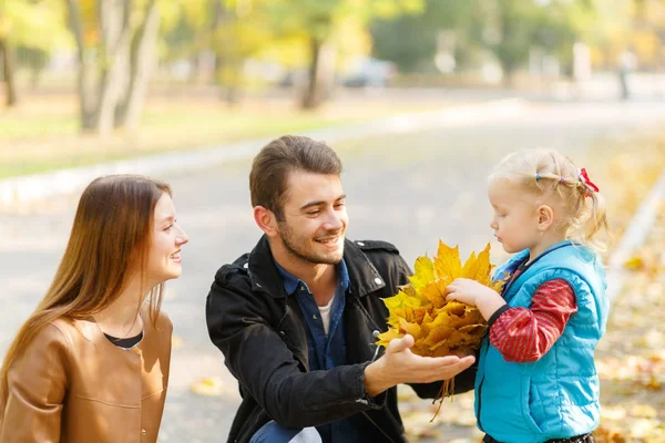 Família em um passeio no fundo do outono amarelo — Fotografia de Stock