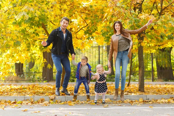 Famille, enfance, concept d'amour. Bonne famille jouant avec les feuilles d'automne dans le parc. Vacances en famille. Maman et papa avec des enfants . — Photo