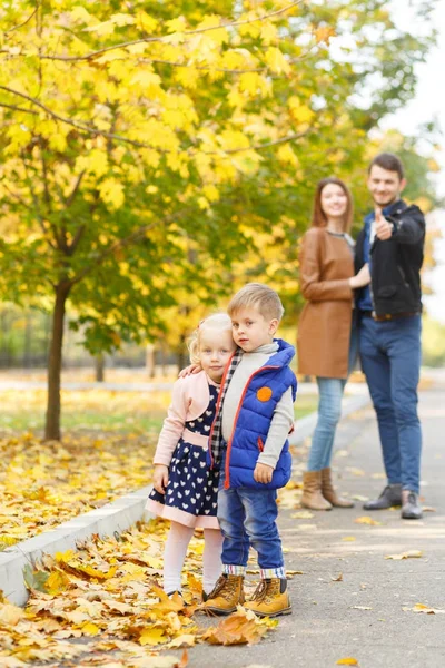 Семья на прогулке на фоне желтой осени — стоковое фото