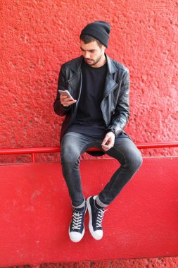 Kırmızı bir arka plan kameraya poz yakışıklı genç.