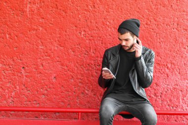 Kırmızı zemin üzerine konuşmak telefon ile yakışıklı genç..