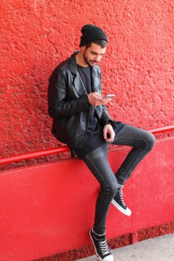 Kırmızı bir arka plan kameraya poz yakışıklı genç.