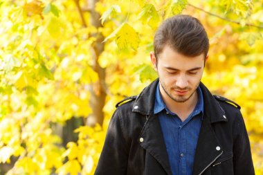 Yakışıklı çocuk doğa arka plan kameraya poz.