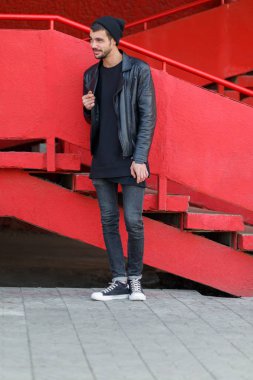 Kırmızı bir arka plan kameraya poz yakışıklı genç.