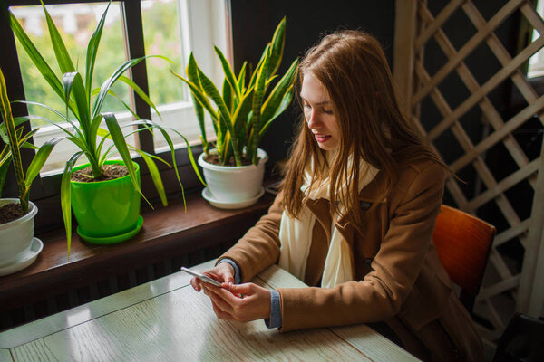Beautiful young girl having fun in the cafe.