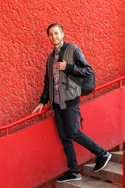 Bonito jovem posando na câmera em um fundo vermelho . — Fotografia de Stock