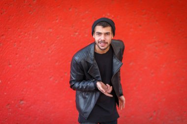 Kırmızı bir arka plan kameraya poz yakışıklı genç.