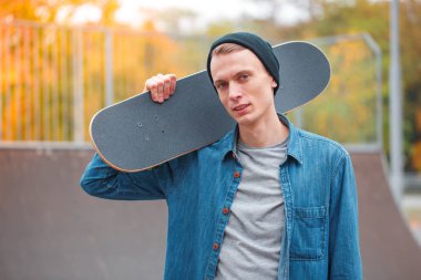 Genç skatebarder skatepark kaykay ile poz. Spor kavramı.