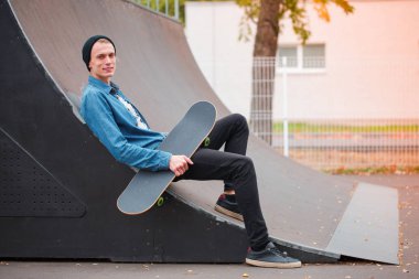 Genç skatebarder skatepark kaykay ile poz. Spor kavramı.