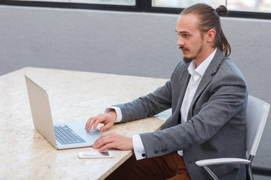 Mutlu adam ofiste oturan ve kucak tepe ile çalışma. İş kavramı.
