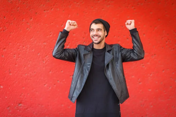 Bonito jovem posando na câmera em um fundo vermelho . — Fotografia de Stock